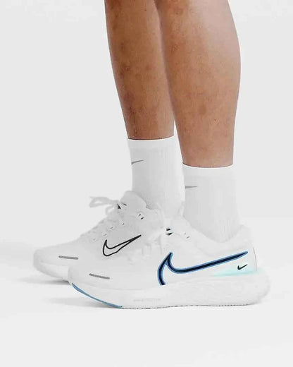 person wearing white athletic running shoes with blue detailing and white socks